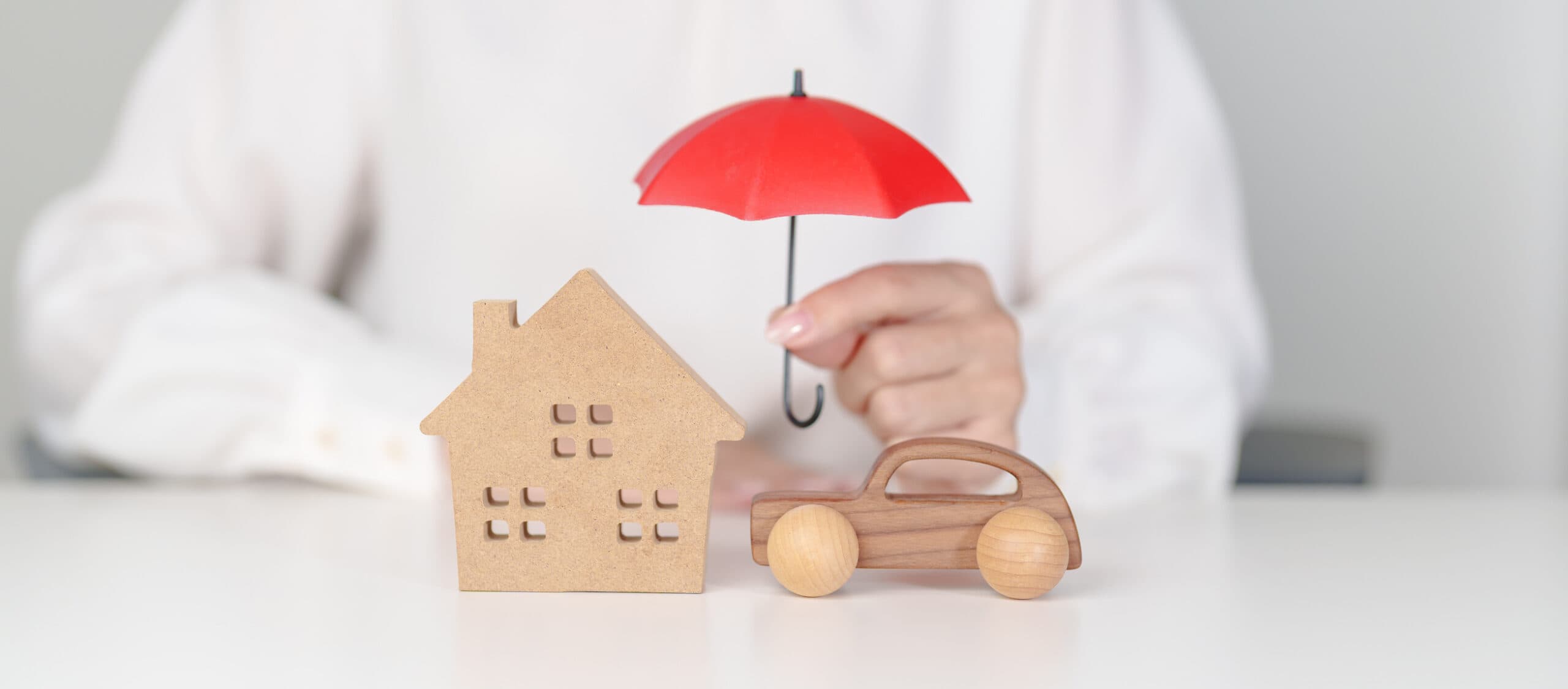 Travelers insurance review showing bundled home and auto insurance protection with a house and car under an umbrella