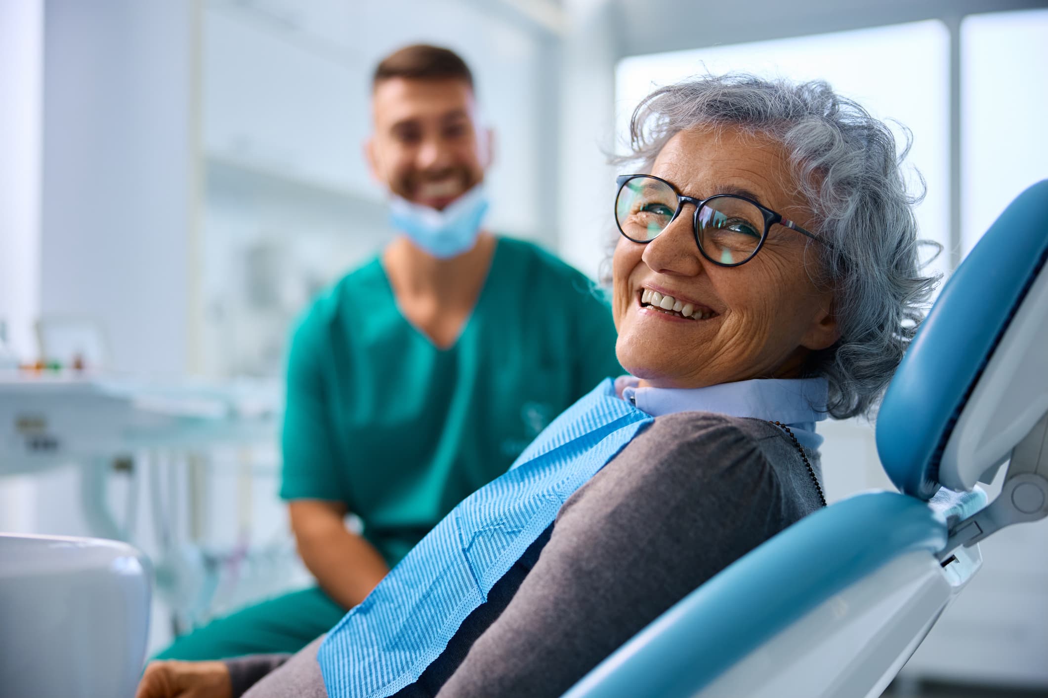 Dental insurance for seniors on Medicare showing an older woman smiling during a dental visit