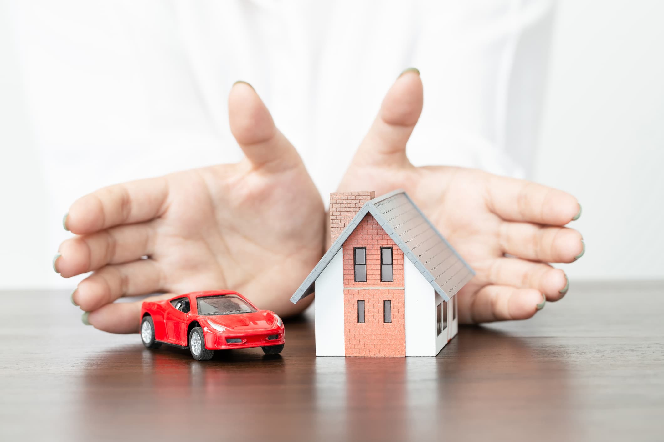 Nationwide insurance review showing bundled home and auto insurance protection with a house and car protected by hands