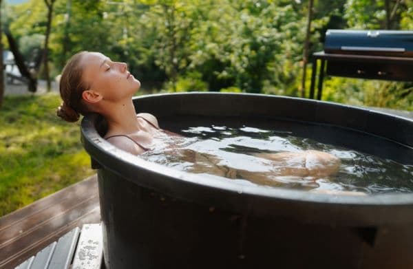 the best cold plunge tub feature image with woman relaxing in cold plunge tub