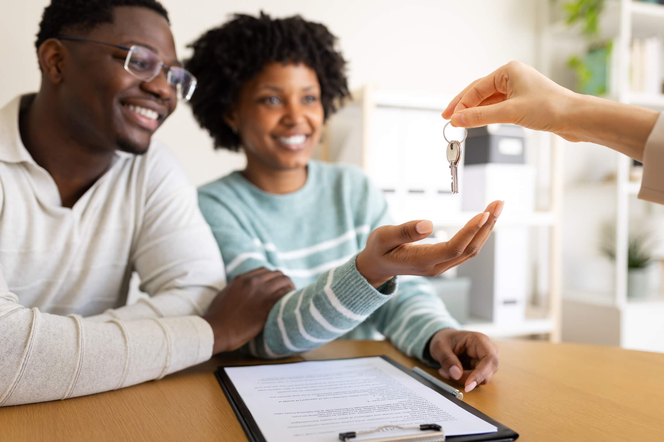 A couple receives the keys to a new home, illustrating the transition from managing debt through consolidation to becoming financially ready for homeownership.