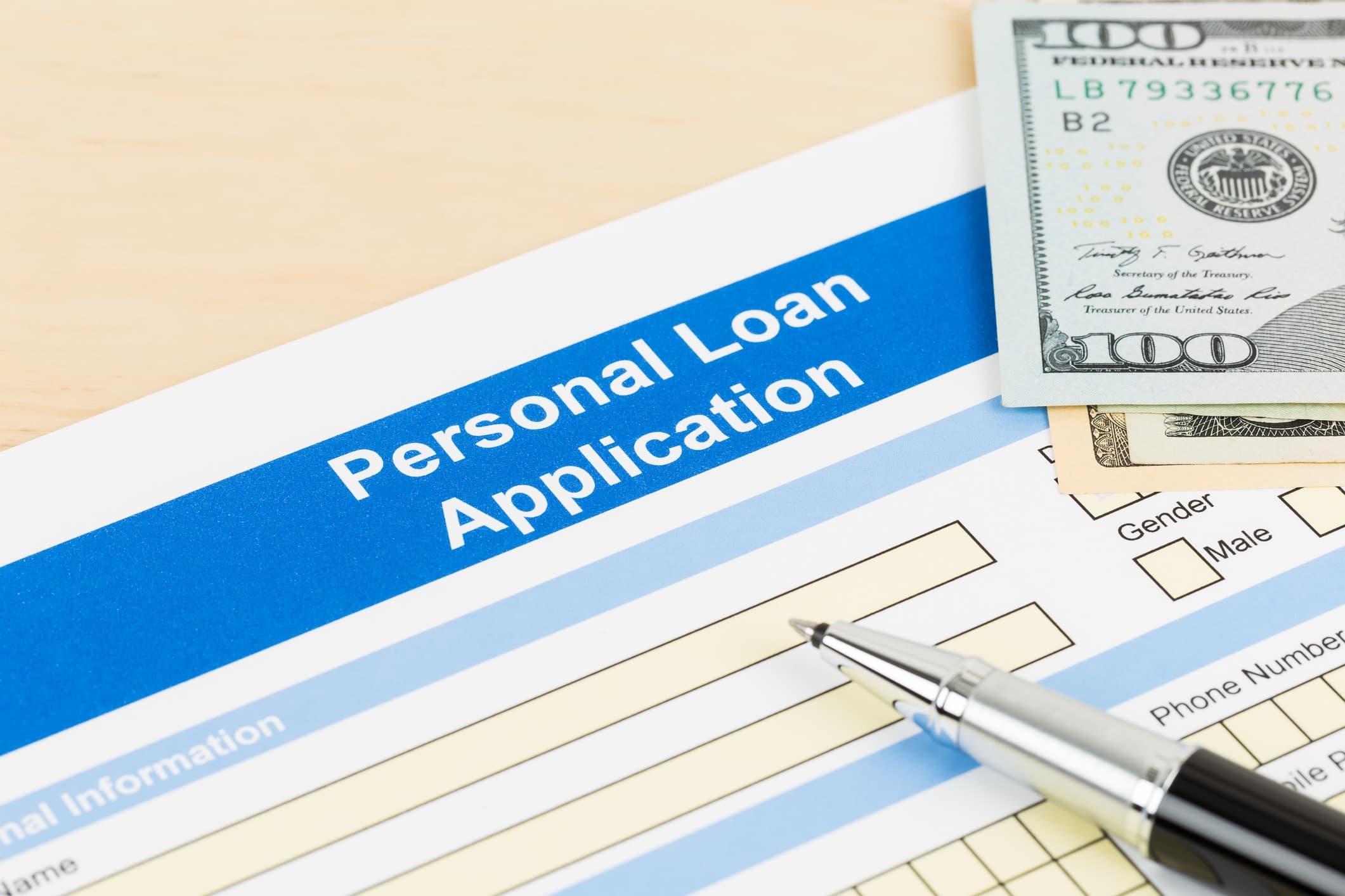 Personal loan application form with cash and pen, representing the lending process for LightStream loan review.