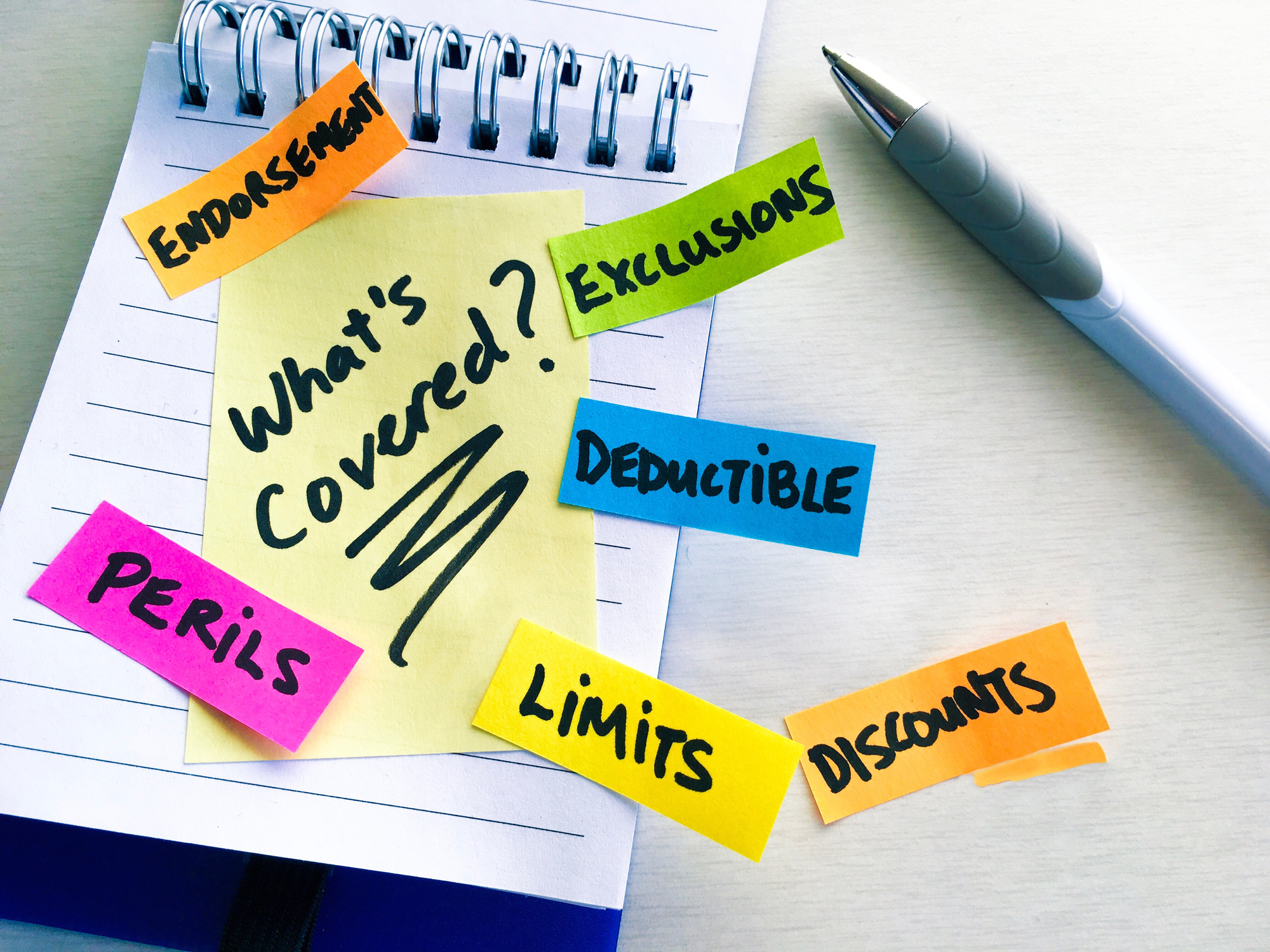 Notebook with insurance terms and sticky notes – do you need renters insurance