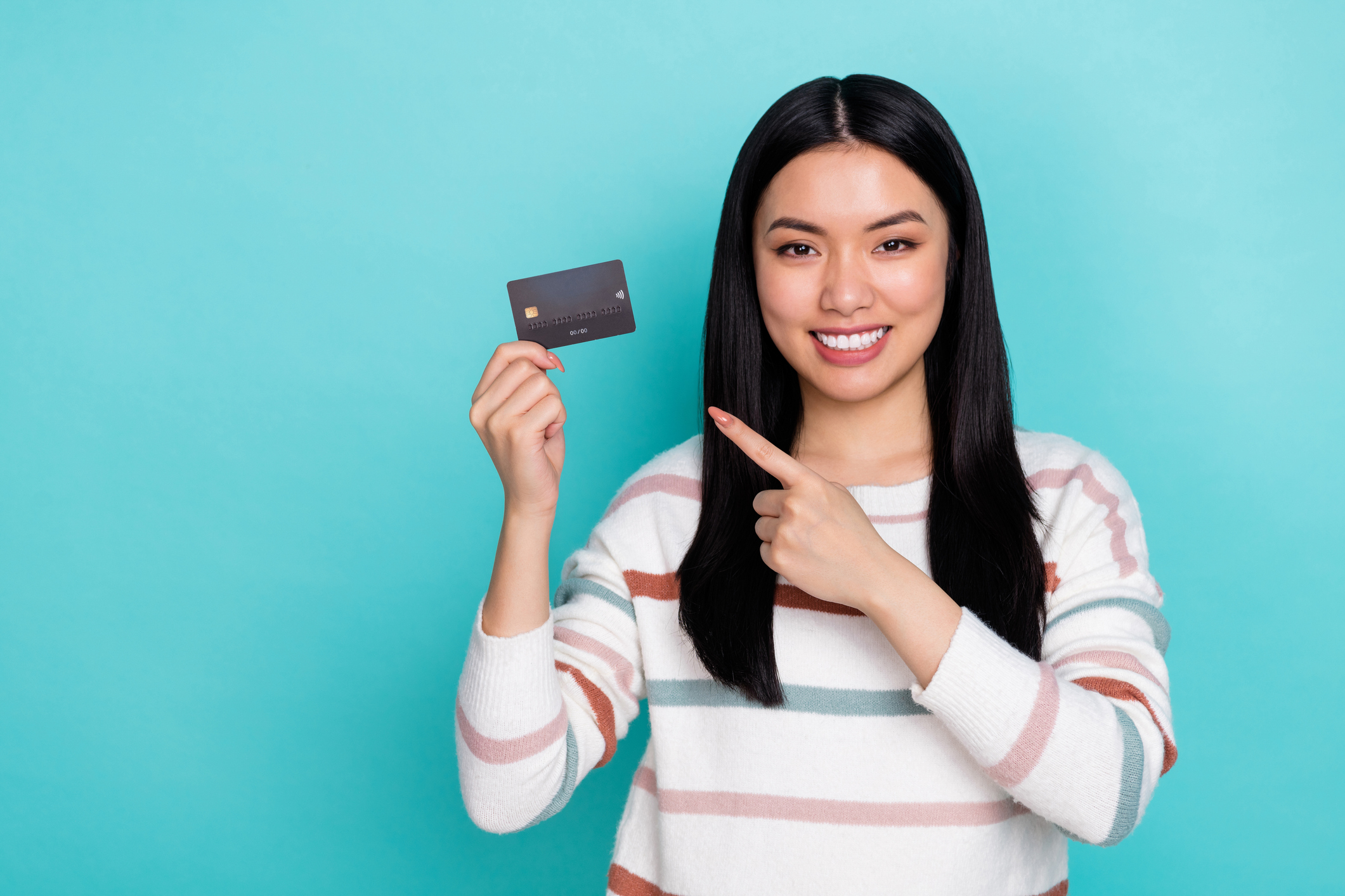 Woman smiling and holding a credit card, representing the best catch-all credit cards