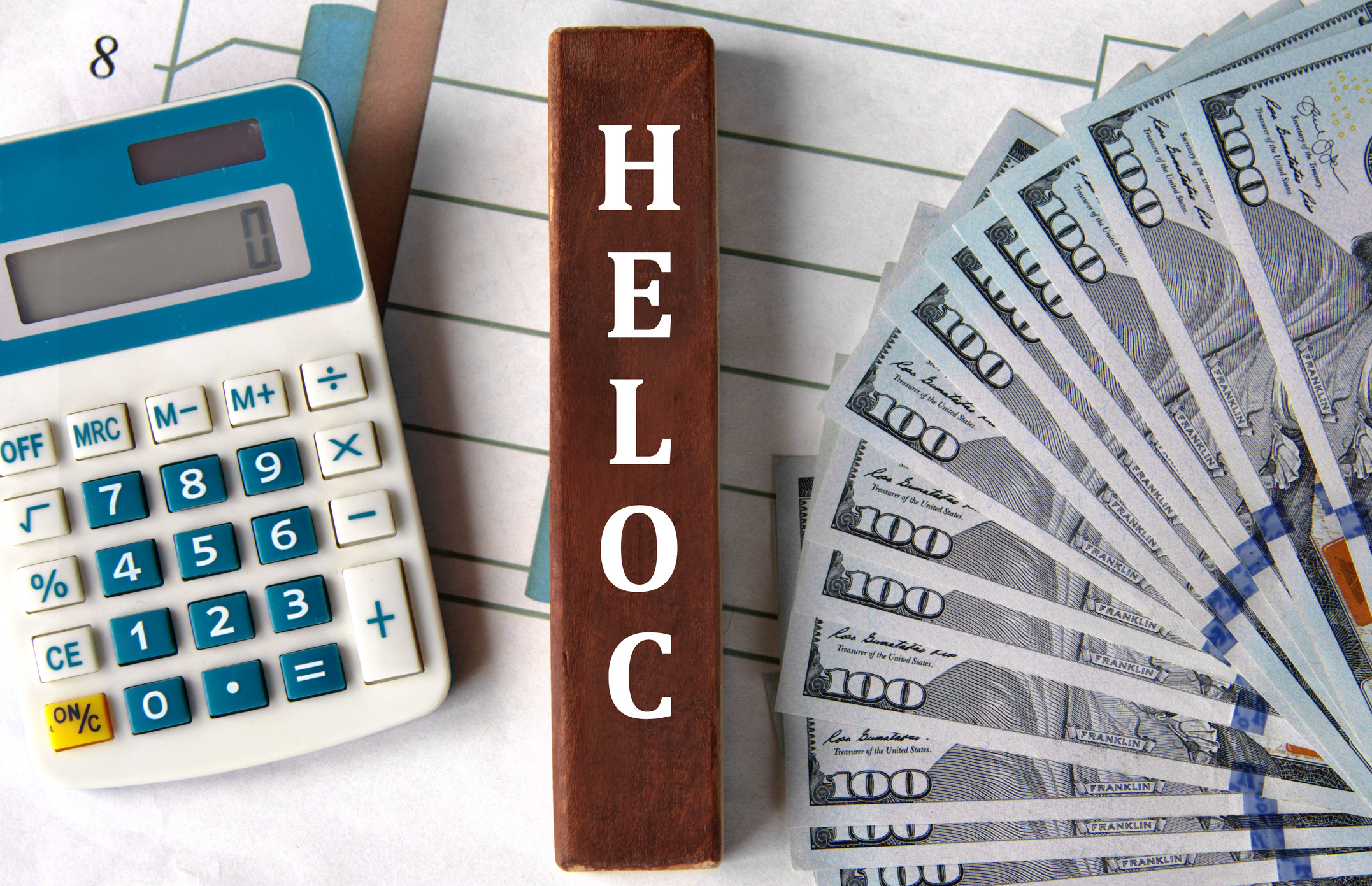 Calculator, cash, and HELOC label displayed together to represent how a HELOC payment calculator helps estimate monthly payments and borrowing limits.