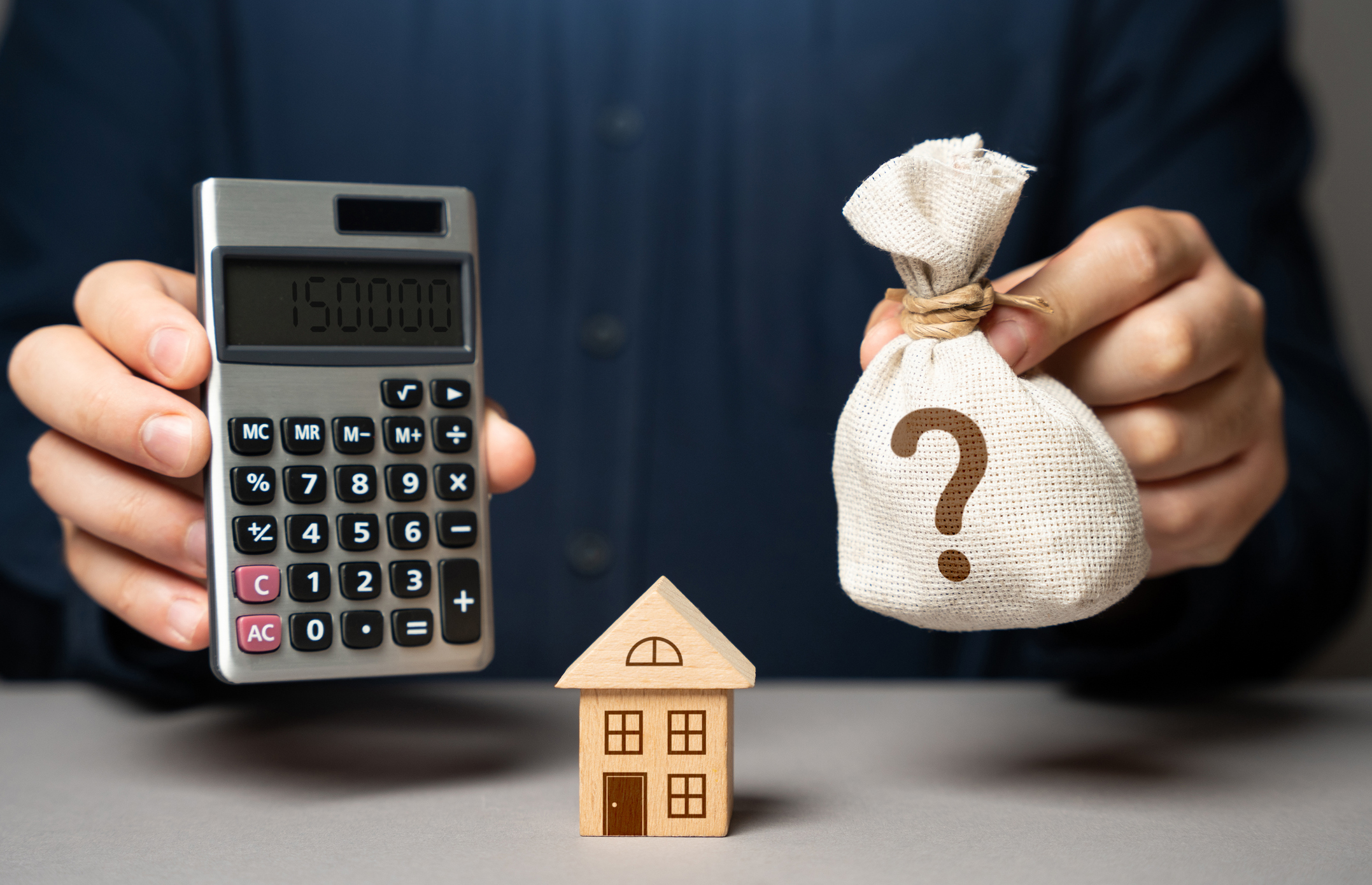 How much home can I afford calculator showing a calculator, house model, and money bag to represent home affordability