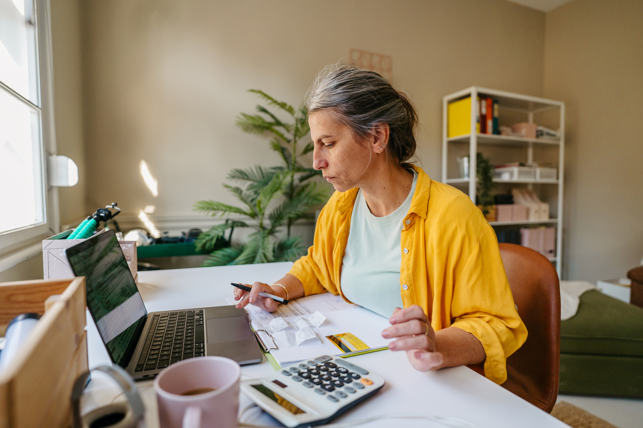 Woman reviewing bills and exploring alternatives to bankruptcy at home office desk