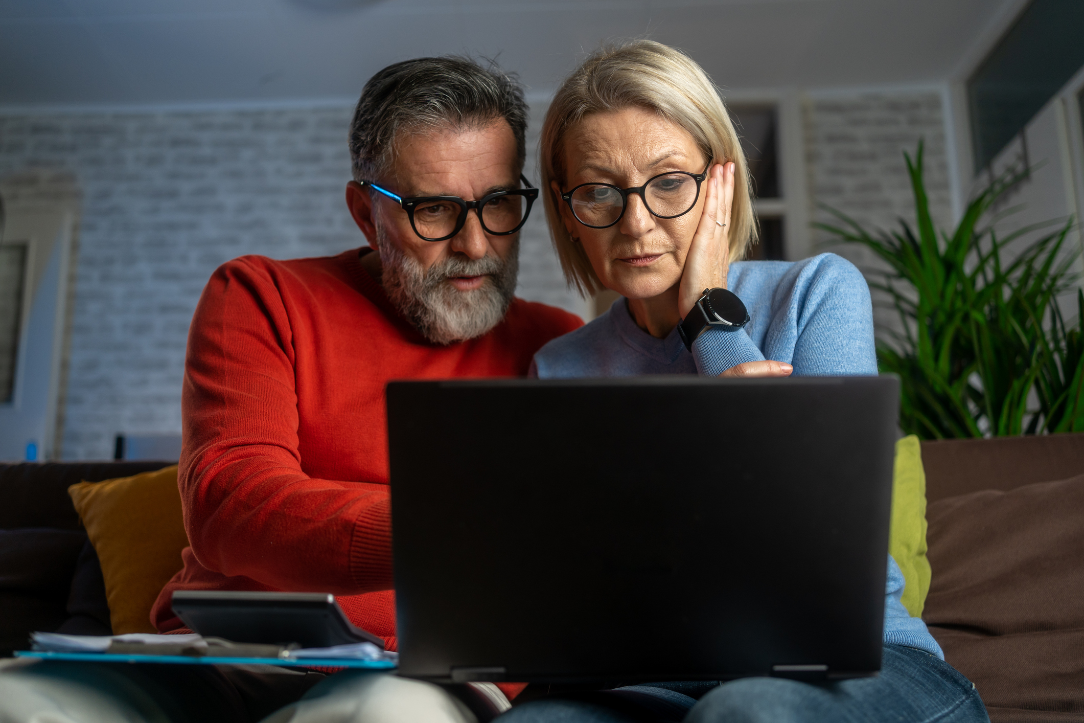 Couple comparing Chapter 7 vs Chapter 13 bankruptcy options on laptop at home