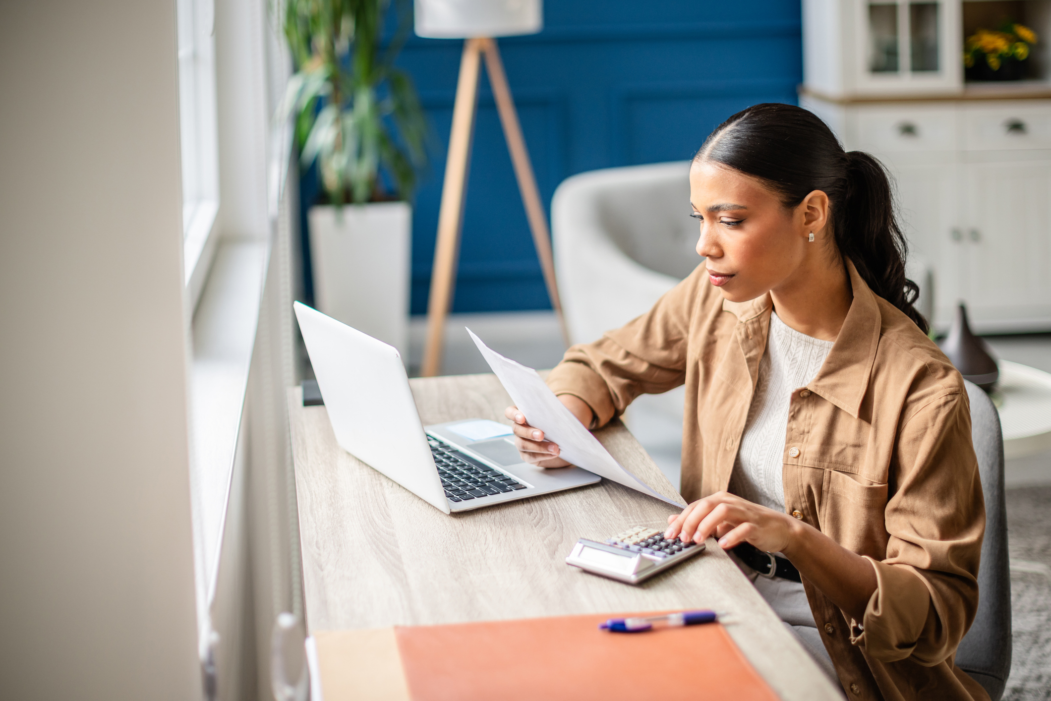 Woman reviewing finances and checking her rate for a debt consolidation loan without hurting her credit
