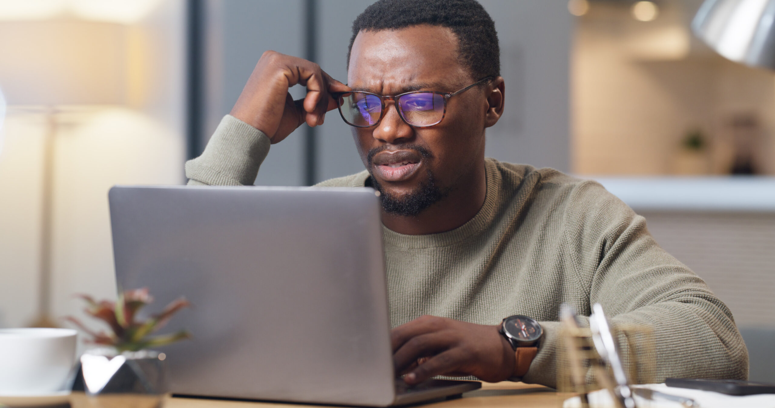 Man researching credit card debt forgiveness scams and legitimate debt relief options online
